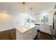 Open-concept kitchen featuring a white quartz island, stainless steel appliances, and modern lighting at 3512 Fairlane Nw Dr, Atlanta, GA 30331