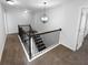 Hallway staircase features iron railing, neutral carpet, and modern lighting fixture at 362 Reserve Overlook, Canton, GA 30115