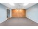 Large basement space featuring neutral carpet, wood paneling, and a ceiling fan at 540 Clubfield Drive, Roswell, GA 30075