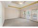 Bright bedroom with tray ceiling, carpet, and doors to the outdoor deck at 540 Clubfield Drive, Roswell, GA 30075