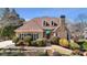 Charming home with a stone chimney, arched windows, manicured bushes, and a quaint front entrance with green awning at 540 Clubfield Drive, Roswell, GA 30075