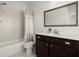Well-lit bathroom with a shower-tub combo and stylish vanity with a dark wood finish at 4000 Bethelview Ln, Suwanee, GA 30024