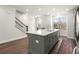 Kitchen island with bar seating, stainless steel dishwasher and an open view to staircase at 4000 Bethelview Ln, Suwanee, GA 30024