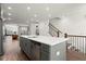 Stylish kitchen island with seating and sink, stainless steel appliances, and open view to staircase at 4000 Bethelview Ln, Suwanee, GA 30024
