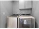Modern laundry room with front load washer and dryer and overhead cabinets at 4000 Bethelview Ln, Suwanee, GA 30024