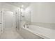Elegant main bathroom featuring a glass shower, soaking tub, and stylish tile floors at 4000 Bethelview Ln, Suwanee, GA 30024