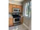 Well-lit kitchen with stainless steel appliances, wood cabinets, mosaic backsplash and tile floor at 330 9Th Ne St # 11, Atlanta, GA 30309
