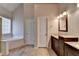 Bright bathroom showcasing a soaking tub with a window and a double vanity with granite countertops at 1541 Towne Park Ct, Lawrenceville, GA 30044