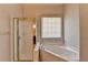 Bathroom featuring a soaking tub next to a glass enclosed shower and a window with blinds at 1541 Towne Park Ct, Lawrenceville, GA 30044