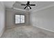 Large bedroom with tray ceiling, ceiling fan and neutral carpet at 1541 Towne Park Ct, Lawrenceville, GA 30044