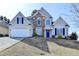 Charming two-story home with stone accents, a blue front door, and a well-manicured front yard at 1541 Towne Park Ct, Lawrenceville, GA 30044