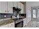 Updated kitchen features black backsplash, stainless steel oven and marble-style floors at 1541 Towne Park Ct, Lawrenceville, GA 30044