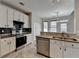 Modern kitchen featuring stainless steel appliances, granite counters, white cabinets and black backsplash at 1541 Towne Park Ct, Lawrenceville, GA 30044