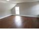 Bedroom featuring hardwood floors, sloped ceiling and a bright window at 444 Sargent Se Dr, Atlanta, GA 30315