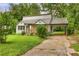 View of the home's front with a carport, lush greenery, and a quaint porch at 444 Sargent Se Dr, Atlanta, GA 30315