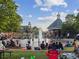 Town square with fountain, green lawn, and people gathered on a sunny day at 1605 Beaumont Cir, Duluth, GA 30096