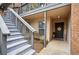 Apartment entrance with gray staircase, black front door with wreath, and tidy landscaping at 1605 Beaumont Cir, Duluth, GA 30096