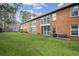 View of the back of a brick townhome building showing the grass yard and the exterior features at 1605 Beaumont Cir, Duluth, GA 30096