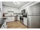 Modern kitchen with stainless steel appliances, white cabinets, and granite countertops at 1605 Beaumont Cir, Duluth, GA 30096