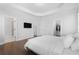 Bright bedroom with wooden floors, tray ceiling, large tv, and access to ensuite bathroom and closet at 174 Sidney St, Marietta, GA 30060