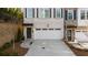 New construction townhome with two car garage, dark window shutters, and professional landscaping at 174 Sidney St, Marietta, GA 30060