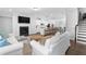 Open concept living area with fireplace and hardwood floors leading to the kitchen and staircase at 174 Sidney St, Marietta, GA 30060