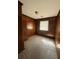 Simple bedroom with wood paneled walls and carpeted floor; a bright window lets in natural light at 2541 Santa Barbara Nw Dr, Atlanta, GA 30318