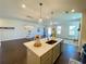 Open-concept kitchen island with modern lighting, perfect for entertaining and adjacent to the spacious living room at 2785 Lifford Way, Duluth, GA 30097