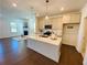 Kitchen island view featuring modern finishes and fixtures, alongside the living room with a fireplace at 2785 Lifford Way, Duluth, GA 30097