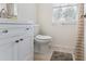 Bright bathroom with modern fixtures, neutral tile, and convenient storage at 3934 Conley Downs Ln, Decatur, GA 30034