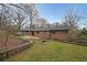 Spacious backyard featuring a terraced stone retaining wall and mature trees, offering privacy and natural beauty at 1072 Powell Wright Rd, Marietta, GA 30066