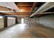 Unfinished basement with concrete floors, exposed ceiling, shelving, and a garage door at 1072 Powell Wright Rd, Marietta, GA 30066