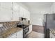 Bright kitchen featuring granite counters, stainless appliances, and mosaic tile backsplash at 55 Sunset Rd, Mcdonough, GA 30253