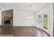 Bright dining room with wood floors, modern chandelier, fireplace, and access to the backyard at 55 Sunset Rd, Mcdonough, GA 30253