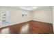 Bright living room with gleaming hardwood floors, a window, and a door to the outside at 55 Sunset Rd, Mcdonough, GA 30253