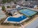 Aerial view showcasing a community pool, tennis courts, clubhouse, and townhomes, emphasizing recreational amenities at 3318 Sardis Bend Dr, Buford, GA 30519