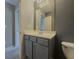Stylish bathroom with gray vanity, a sink, a modern mirror, and toilet, creating a fresh and clean aesthetic at 3318 Sardis Bend Dr, Buford, GA 30519