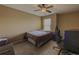 Cozy bedroom with tan walls, carpet, ceiling fan, a window, and a comfortable bed, creating a restful ambiance at 3318 Sardis Bend Dr, Buford, GA 30519