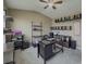 Comfortable home office boasts neutral walls, carpeted flooring, ceiling fan, a black desk, and ample shelving at 3318 Sardis Bend Dr, Buford, GA 30519