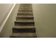 Carpeted staircase with white railing providing access to upper or lower levels of the residence at 402 Pine Tree Trl, Atlanta, GA 30349