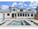 Backyard view with a gunite pool, lounge chairs, and white brick house with black framed windows at 4100 Thunderbird Dr, Marietta, GA 30067