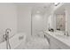 Spa-like bathroom boasts a soaking tub, sleek fixtures, marble floors, and a glass-enclosed shower at 4100 Thunderbird Dr, Marietta, GA 30067