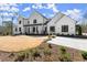 Stunning two-story white home featuring modern design elements and a well-manicured lawn with tasteful landscaping at 4100 Thunderbird Dr, Marietta, GA 30067