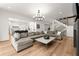 Open living space with hardwood floors, large couch, view of the staircase, and access to the kitchen at 4100 Thunderbird Dr, Marietta, GA 30067