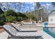 Relaxing poolside view with lounge chairs, a spa, lush landscaping, and an inviting backyard escape from this angle at 4100 Thunderbird Dr, Marietta, GA 30067