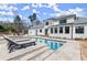 Luxury pool with integrated spa, travertine pavers, and outdoor seating, perfect for relaxing and entertaining near the home at 4100 Thunderbird Dr, Marietta, GA 30067