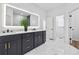 Bright, modern bathroom features a double vanity, a huge mirror with lights, and marble style tile floors at 6010 Canaan Woods Dr, South Fulton, GA 30331