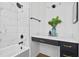 Modern bathroom features a stylish vanity, black hardware, and a bathtub with white marble-style tile at 6010 Canaan Woods Dr, South Fulton, GA 30331
