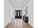 Bright foyer with hard wood floors and neutral decor features a modern front door and console table at 6010 Canaan Woods Dr, South Fulton, GA 30331
