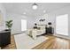 Bright main bedroom boasts wood floors, a tray ceiling, a modern light fixture, and neutral decor at 6010 Canaan Woods Dr, South Fulton, GA 30331